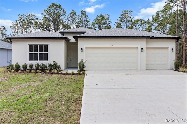 prairie-style home with concrete driveway, a front lawn, an attached garage, and stucco siding