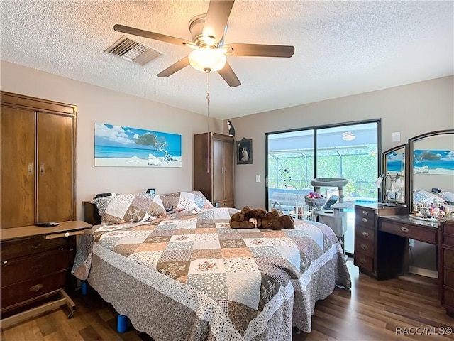bedroom featuring visible vents, ceiling fan, a textured ceiling, dark wood finished floors, and access to exterior