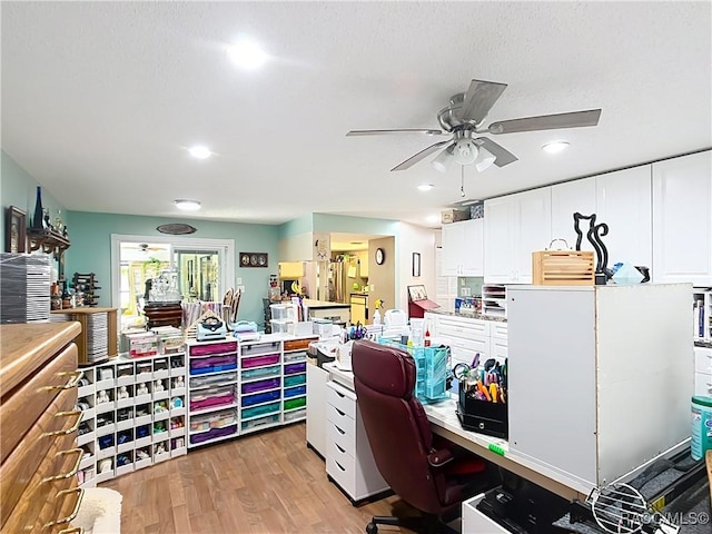 office space with a ceiling fan and light wood-style floors
