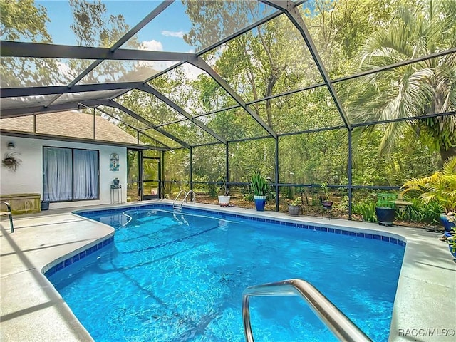 pool featuring a patio area and glass enclosure