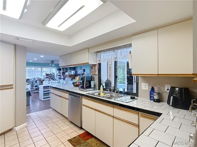 kitchen with tile countertops, a ceiling fan, light tile patterned flooring, dishwasher, and a sink
