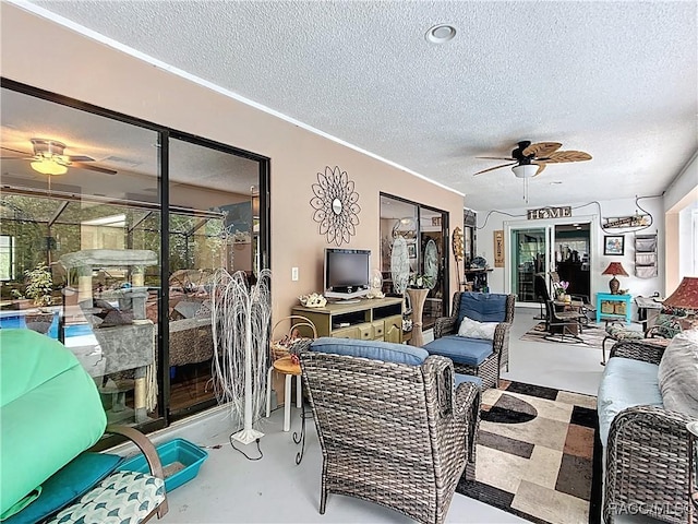 living room with a textured ceiling, finished concrete floors, and ceiling fan