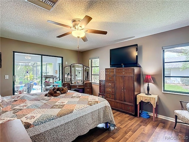 bedroom featuring access to outside, a textured ceiling, visible vents, ceiling fan, and wood finished floors