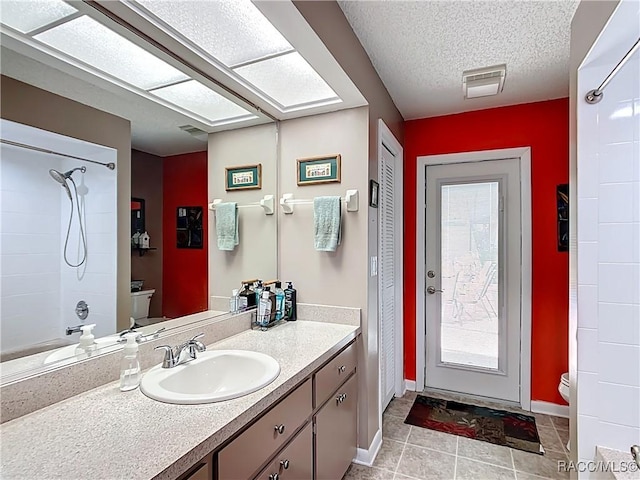 bathroom with visible vents, toilet, a textured ceiling, vanity, and tile patterned flooring
