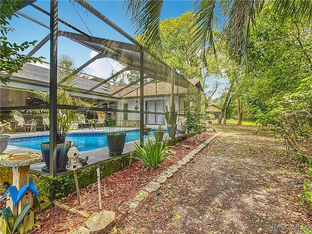 pool with a patio area and glass enclosure
