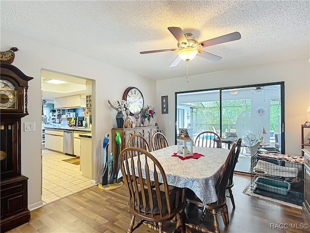 dining space with light wood-style flooring, ceiling fan, and a textured ceiling