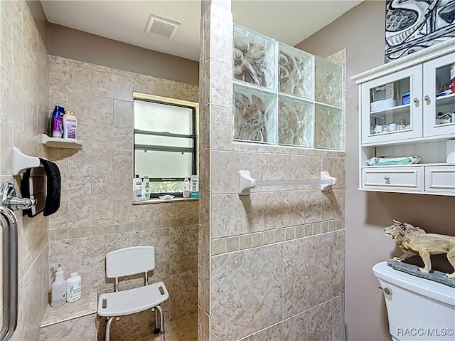 bathroom with toilet, visible vents, and walk in shower