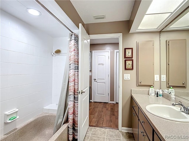 full bathroom featuring visible vents, a shower with curtain, baseboards, and vanity