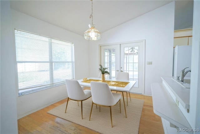 dining room featuring lofted ceiling and light wood-style flooring