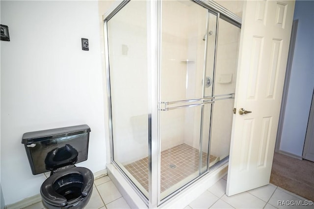 bathroom with tile patterned flooring and a shower stall