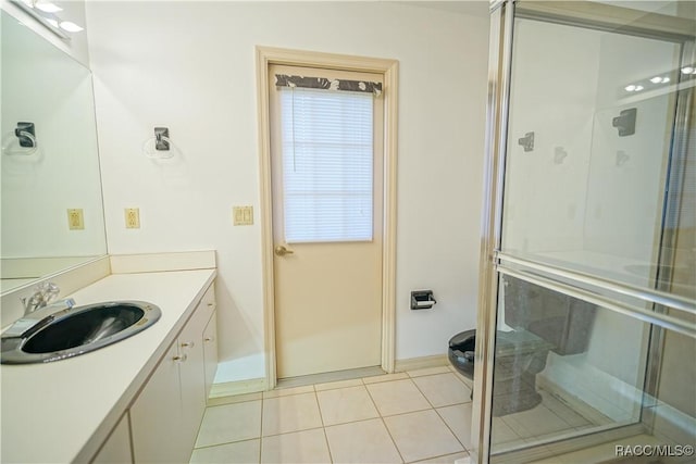 full bath with vanity, tile patterned flooring, and a shower stall