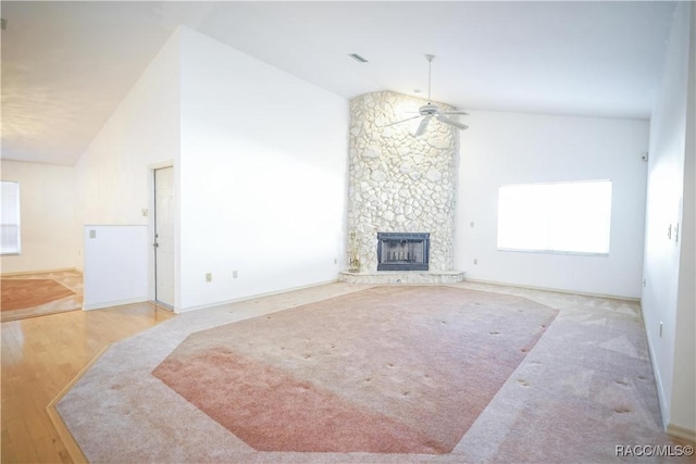 living area with high vaulted ceiling, a ceiling fan, a fireplace, wood finished floors, and visible vents