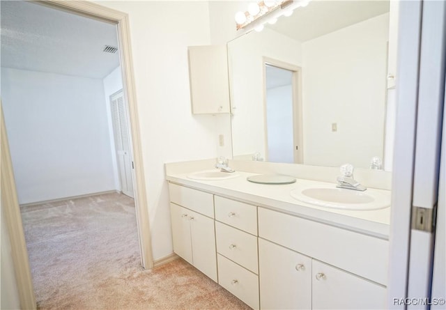 bathroom with double vanity, visible vents, and a sink