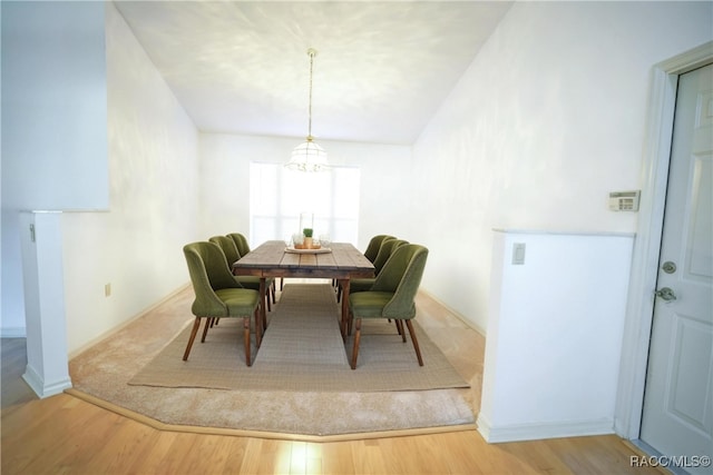 dining space featuring baseboards, wood finished floors, and a chandelier