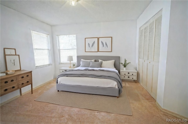 bedroom with light carpet and a closet