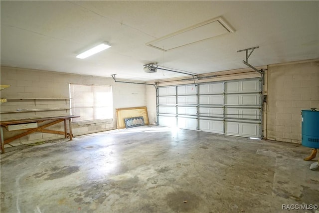 garage with concrete block wall and a garage door opener