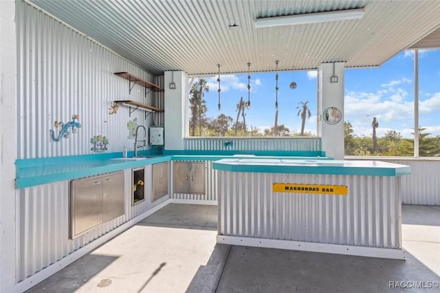 view of patio with exterior kitchen and a sink