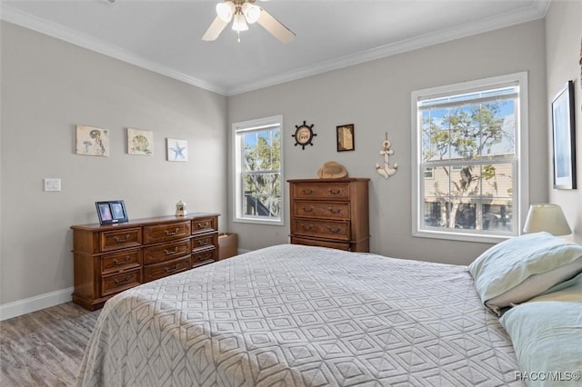 bedroom featuring light wood-style flooring, baseboards, ceiling fan, and crown molding