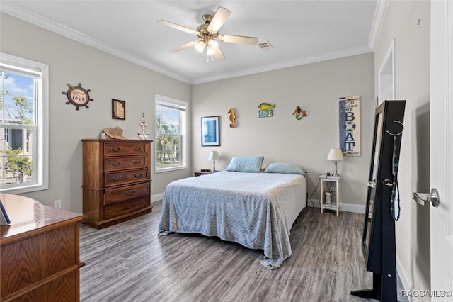 bedroom featuring baseboards, visible vents, ceiling fan, wood finished floors, and crown molding