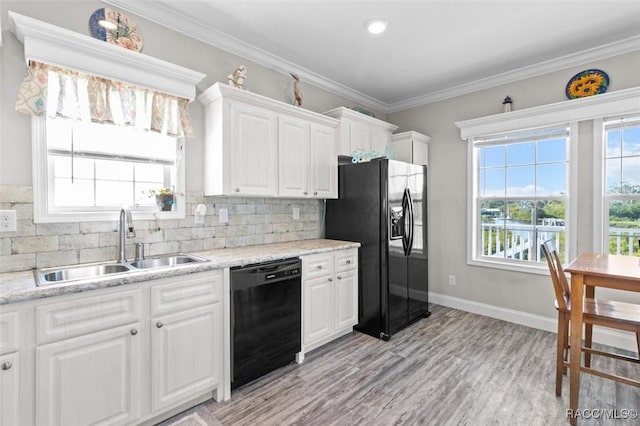 kitchen featuring a sink, white cabinetry, decorative backsplash, black appliances, and crown molding