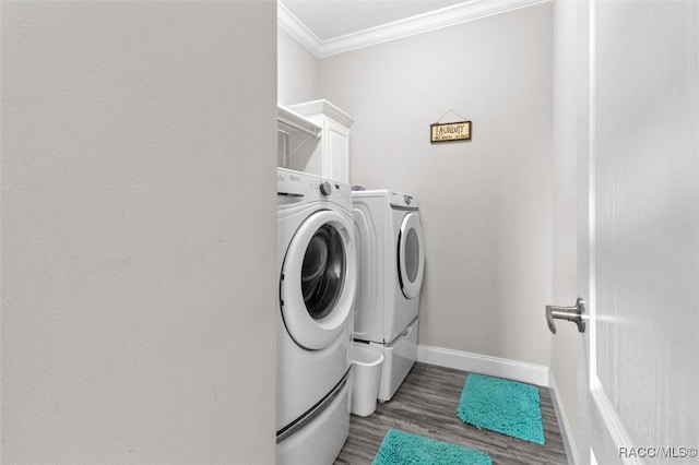 laundry room featuring dark wood-style floors, cabinet space, crown molding, and independent washer and dryer