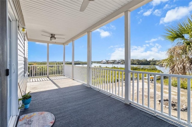 balcony featuring a water view and a ceiling fan