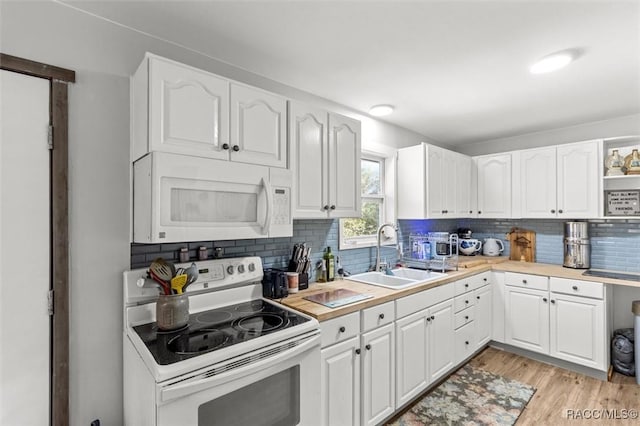 kitchen with white appliances, decorative backsplash, white cabinets, light countertops, and a sink