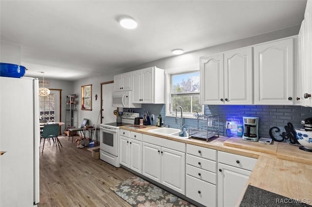 kitchen featuring white appliances, white cabinets, and a sink