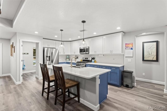 kitchen with white cabinets, decorative light fixtures, blue cabinets, and stainless steel appliances