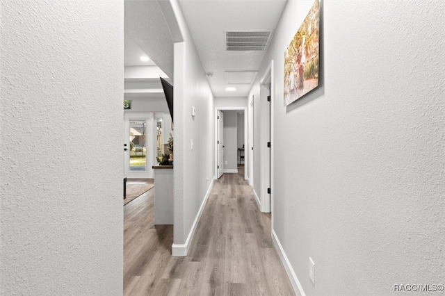 corridor with light hardwood / wood-style flooring