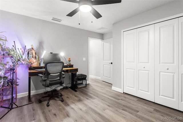 home office with ceiling fan and light hardwood / wood-style floors