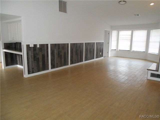 unfurnished room featuring light wood-type flooring and lofted ceiling