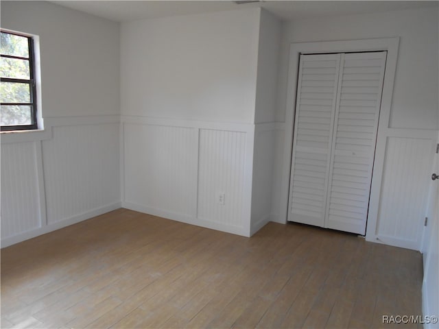 unfurnished bedroom featuring hardwood / wood-style flooring and a closet