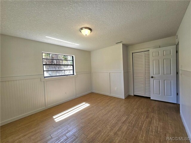 unfurnished bedroom featuring light hardwood / wood-style floors and a closet