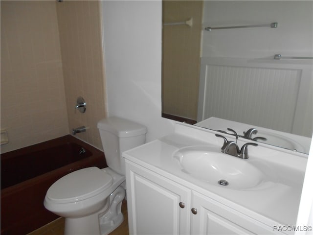 full bathroom featuring vanity, tiled shower / bath combo, and toilet