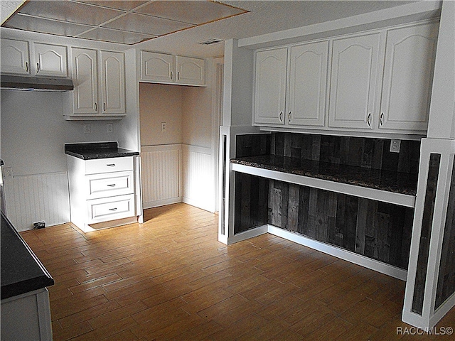 kitchen featuring ventilation hood, dark hardwood / wood-style flooring, and white cabinetry