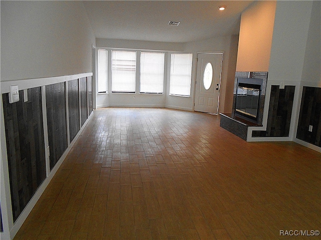 unfurnished living room featuring a tile fireplace and wood-type flooring