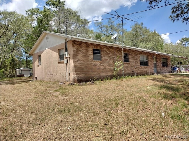view of side of property featuring a yard and brick siding