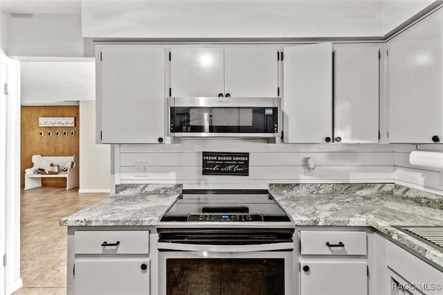 kitchen with white cabinets, light tile patterned flooring, and appliances with stainless steel finishes