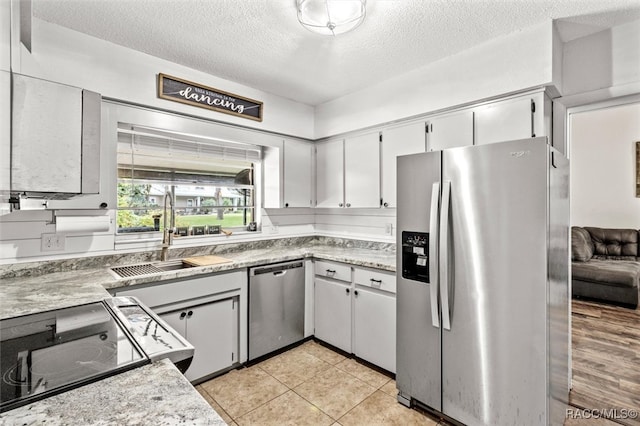 kitchen featuring a textured ceiling, white cabinets, sink, and appliances with stainless steel finishes