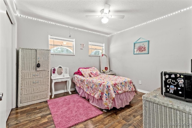 bedroom with dark hardwood / wood-style floors, ceiling fan, and a textured ceiling