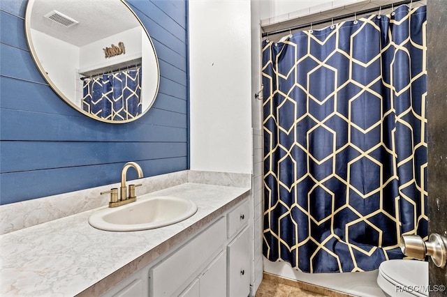 bathroom featuring vanity, toilet, curtained shower, and wood walls