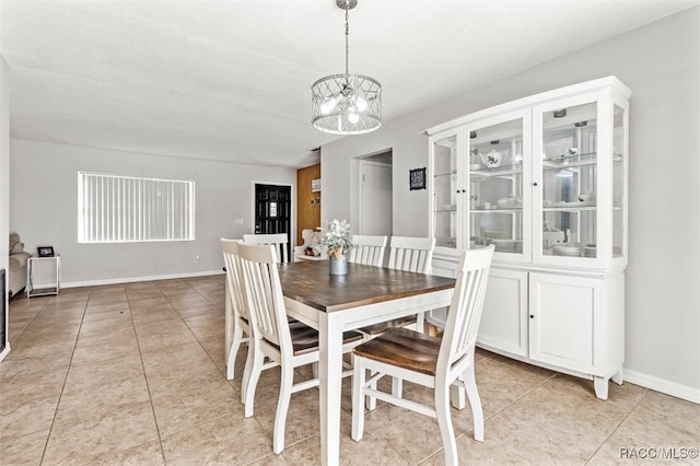 dining room with light tile patterned floors, a textured ceiling, and an inviting chandelier