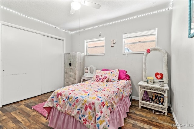 bedroom featuring a closet, ceiling fan, dark hardwood / wood-style flooring, and a textured ceiling