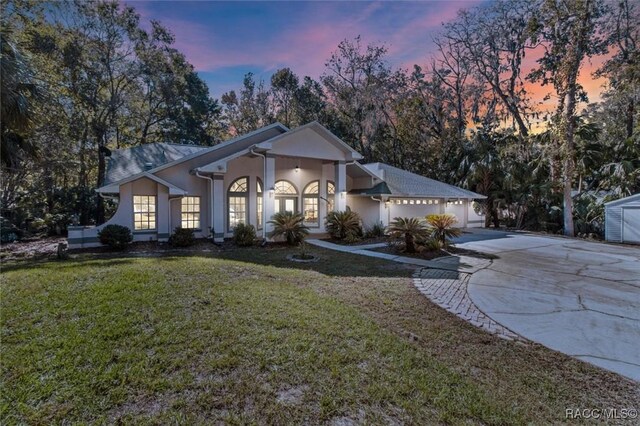 view of front facade featuring french doors and a lawn