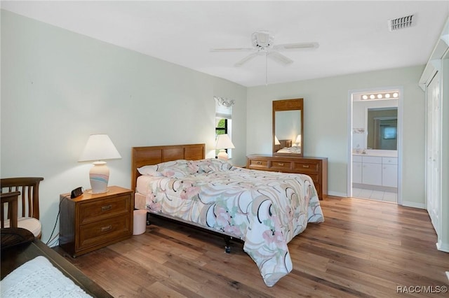 bedroom featuring dark hardwood / wood-style floors, ceiling fan, and connected bathroom