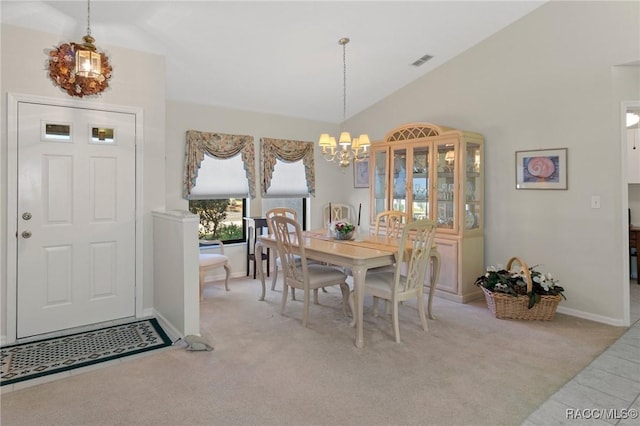 carpeted dining area featuring a notable chandelier and high vaulted ceiling