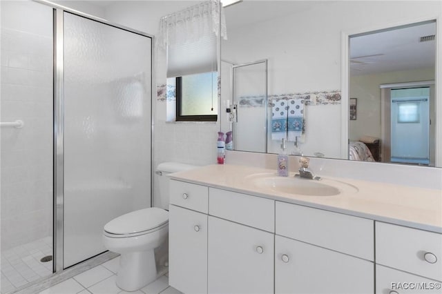 bathroom featuring toilet, vanity, tile patterned floors, and an enclosed shower