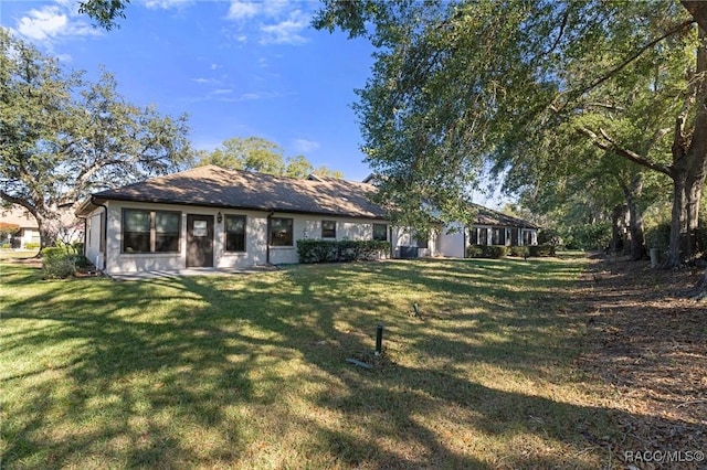 back of house with a lawn