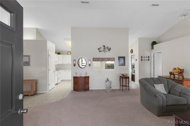 carpeted living room with high vaulted ceiling